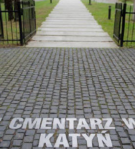 Blick auf einen Friedhof durch das Eingangstor, auf dem Boden stehen die Worte: Polski Cmentarz Wojenny Katyn (imago/stock&people/newspix)