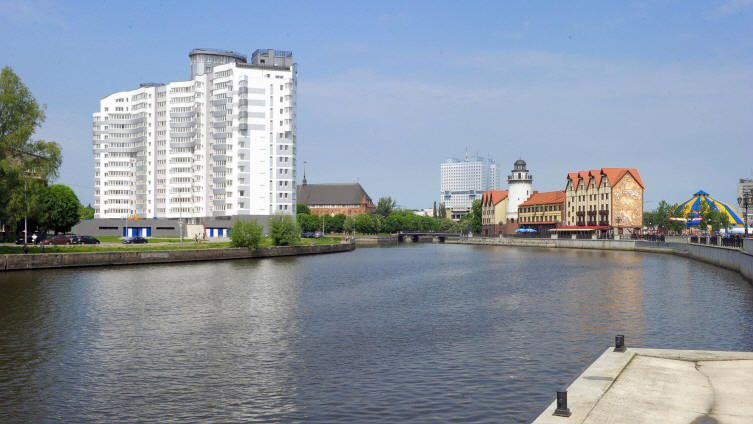 Hinter einer Wasserflche ist ein groes Hochhaus und deneben ein kleines Ensemble historischer Gebude zu sehen. (picture alliance / dpa / Soeren Stache)