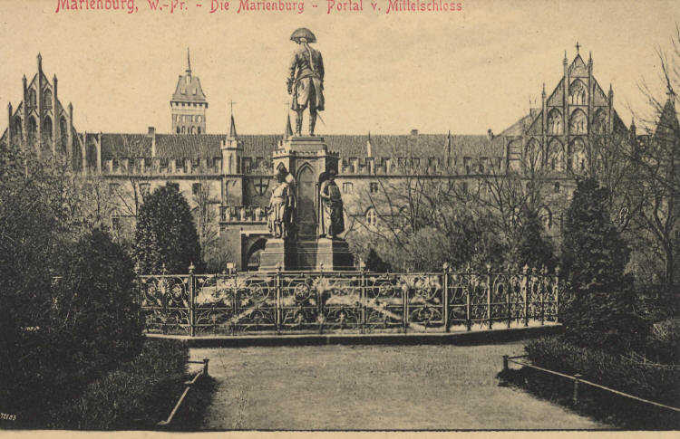 Marienburg (Westpreußen) - Die Marienburg - Portal v. Mittelschloß - Im Vordergrund das Denkmal Friedrichs des Großen auf dem Vorburg-Gelände (heute Parkplatz)